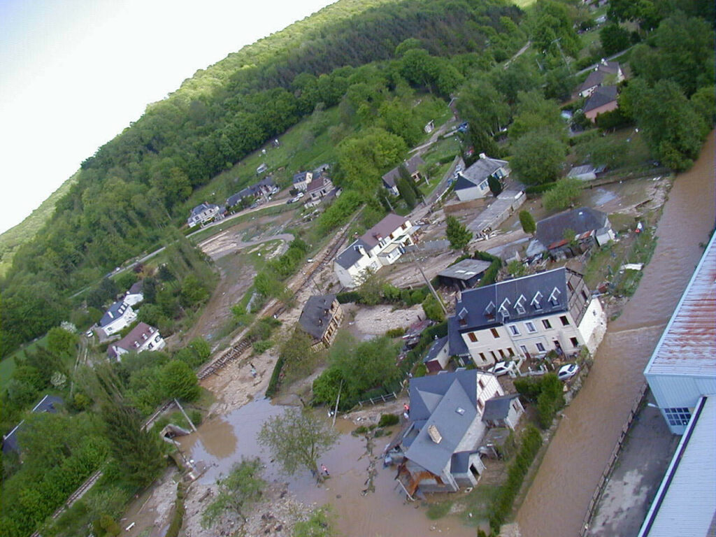 photo aérienne prise après l'inondation du 10 mai, montrant les maisons inondées, la voie de chemin de fer emportée et les traces des ruissellements encore visibles