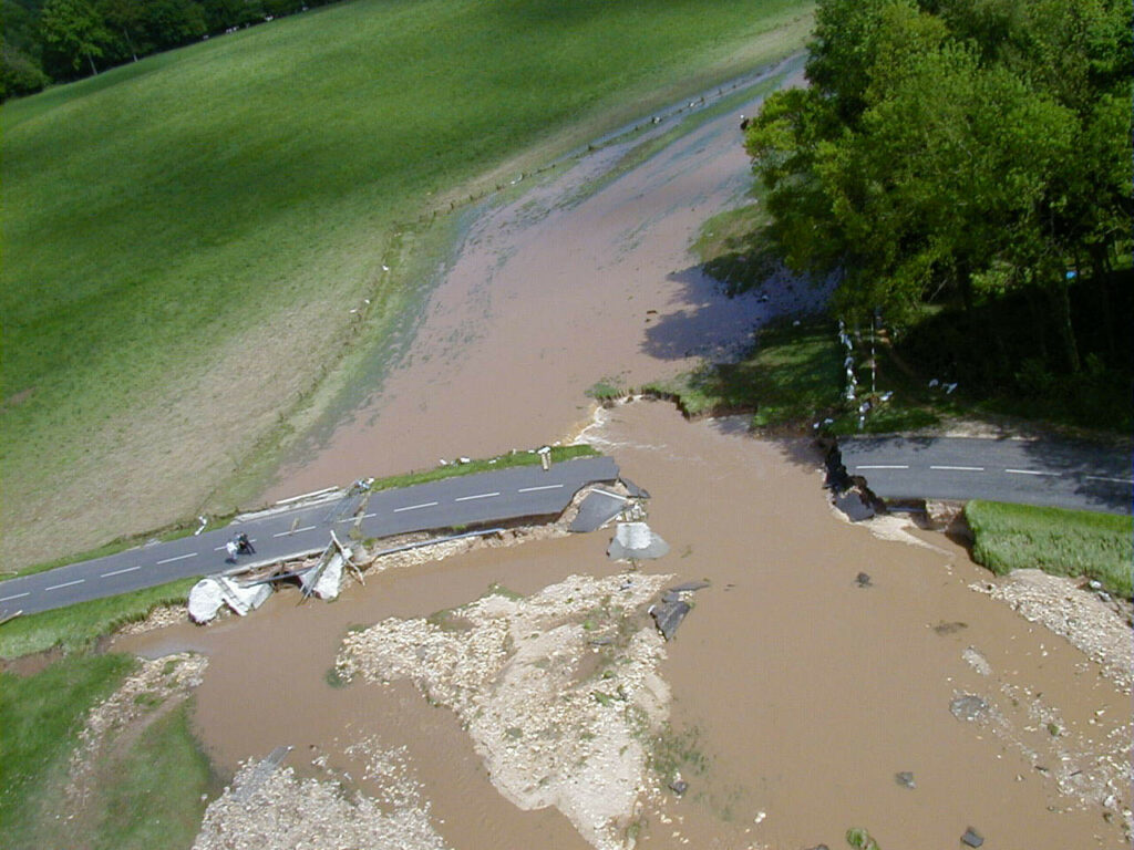 Photo aérienne montrant une route emportée au hameau du Glu à Saint Paër suite aux inondations du 10 mai 2000 (causées par du ruissellement). Source : DREAL Normandie