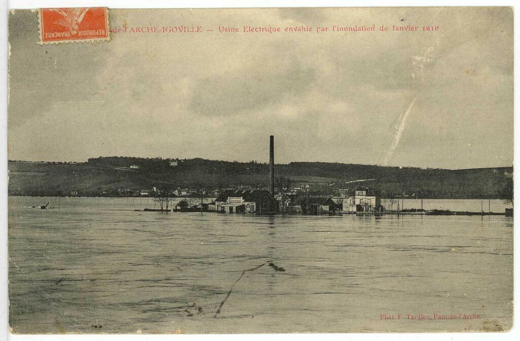 Carte postale 1910. Pont de l'Arche-Igoville : usine électrique envahie par l'inondation de janvier 1910 (source : Archives Départementales 27)
