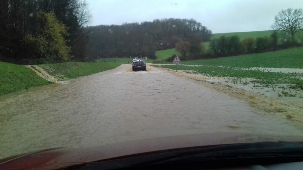 Route inondée par des ruissellements et voitures circulant dessus le 22 janvier 2018